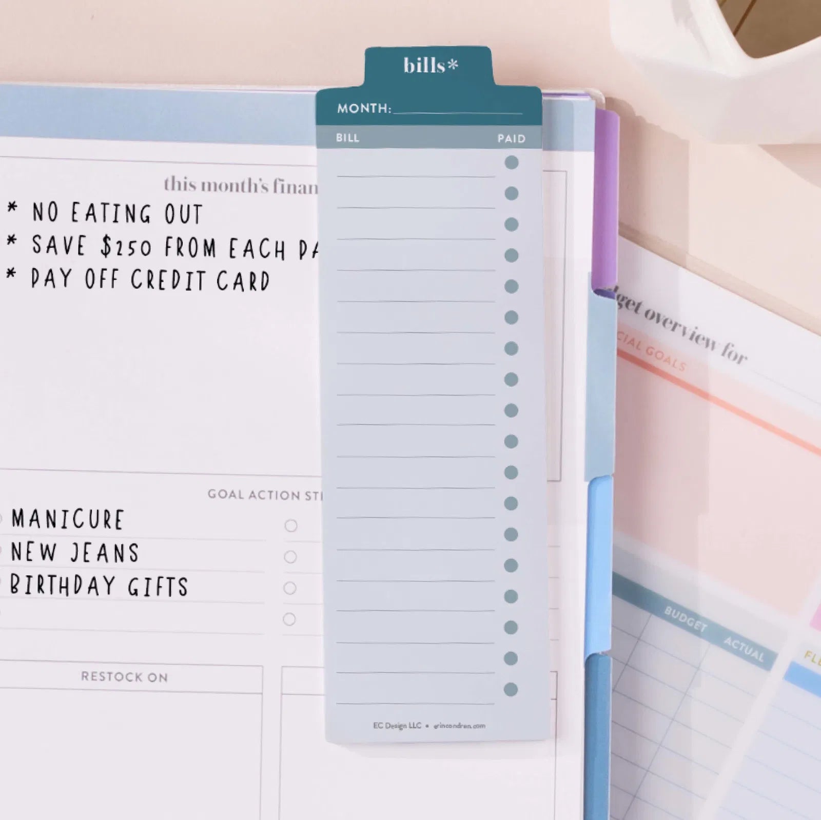 Planner with financial goals and tasks written on it, including no eating out, saving money, and paying off credit cards.