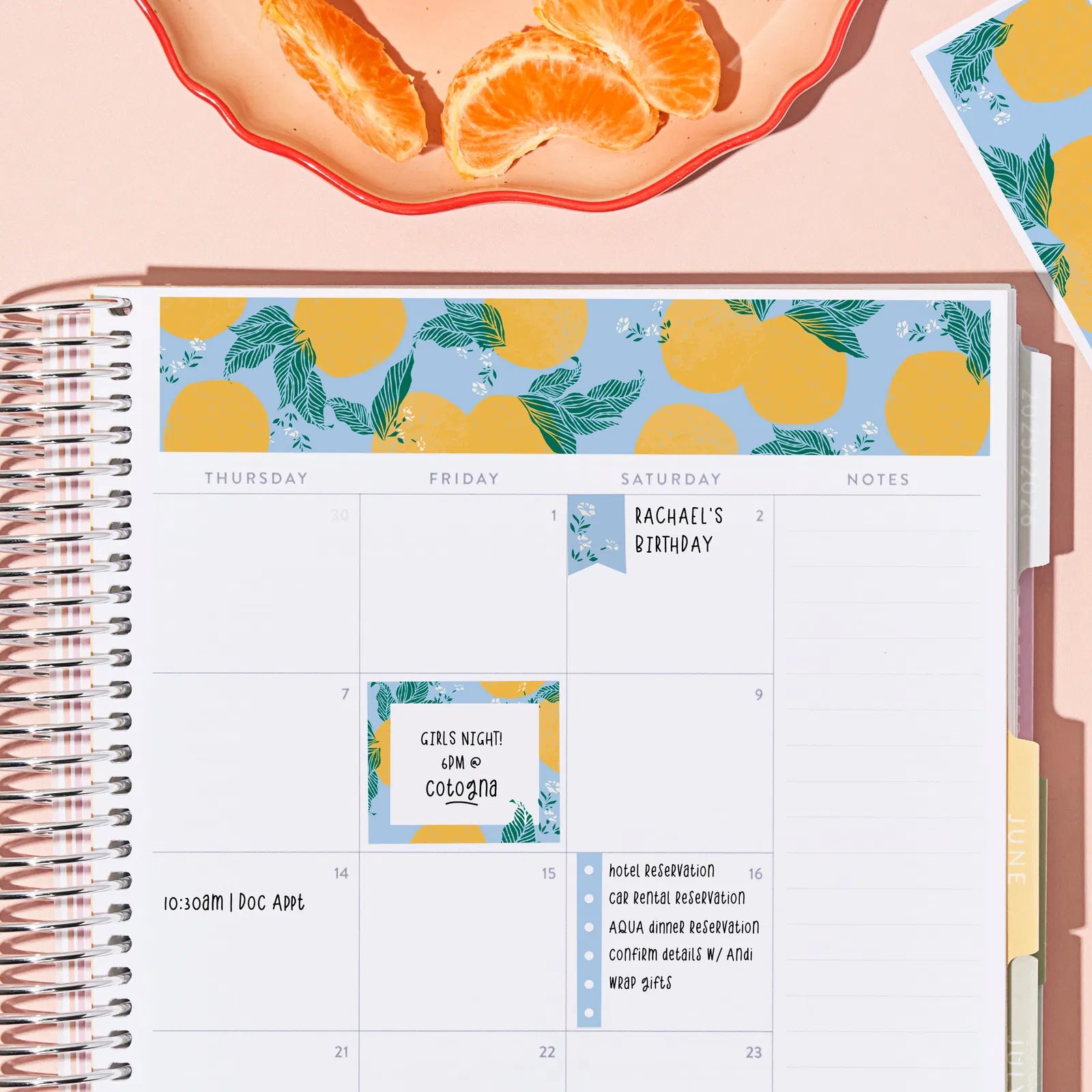 Calendar with lemon pattern on a pink surface with oranges