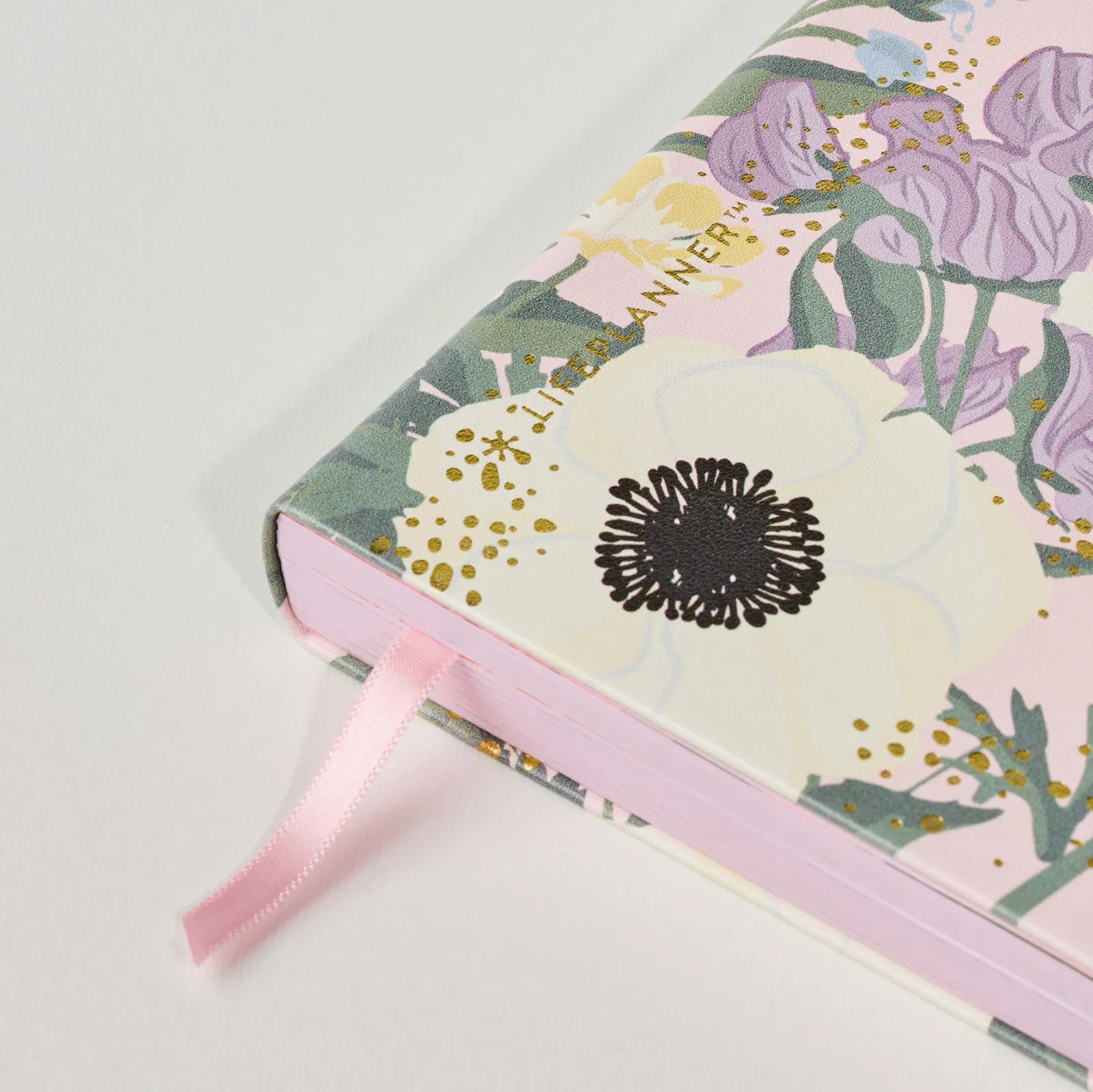 Floral planner with a pink ribbon on a light gray background