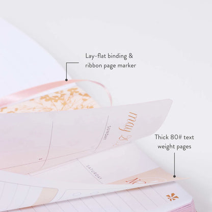 Open notebook with text highlighting features like lay-flat binding, ribbon page marker, and thick text weight pages.