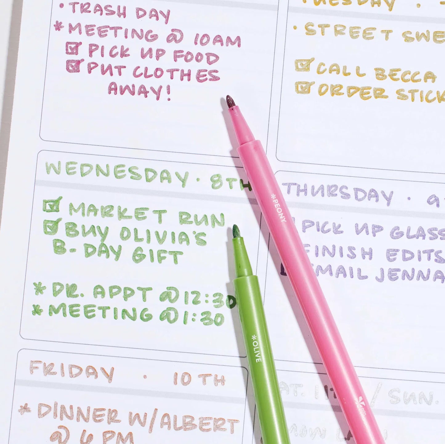 Two highlighters on a planner with daily tasks written out.