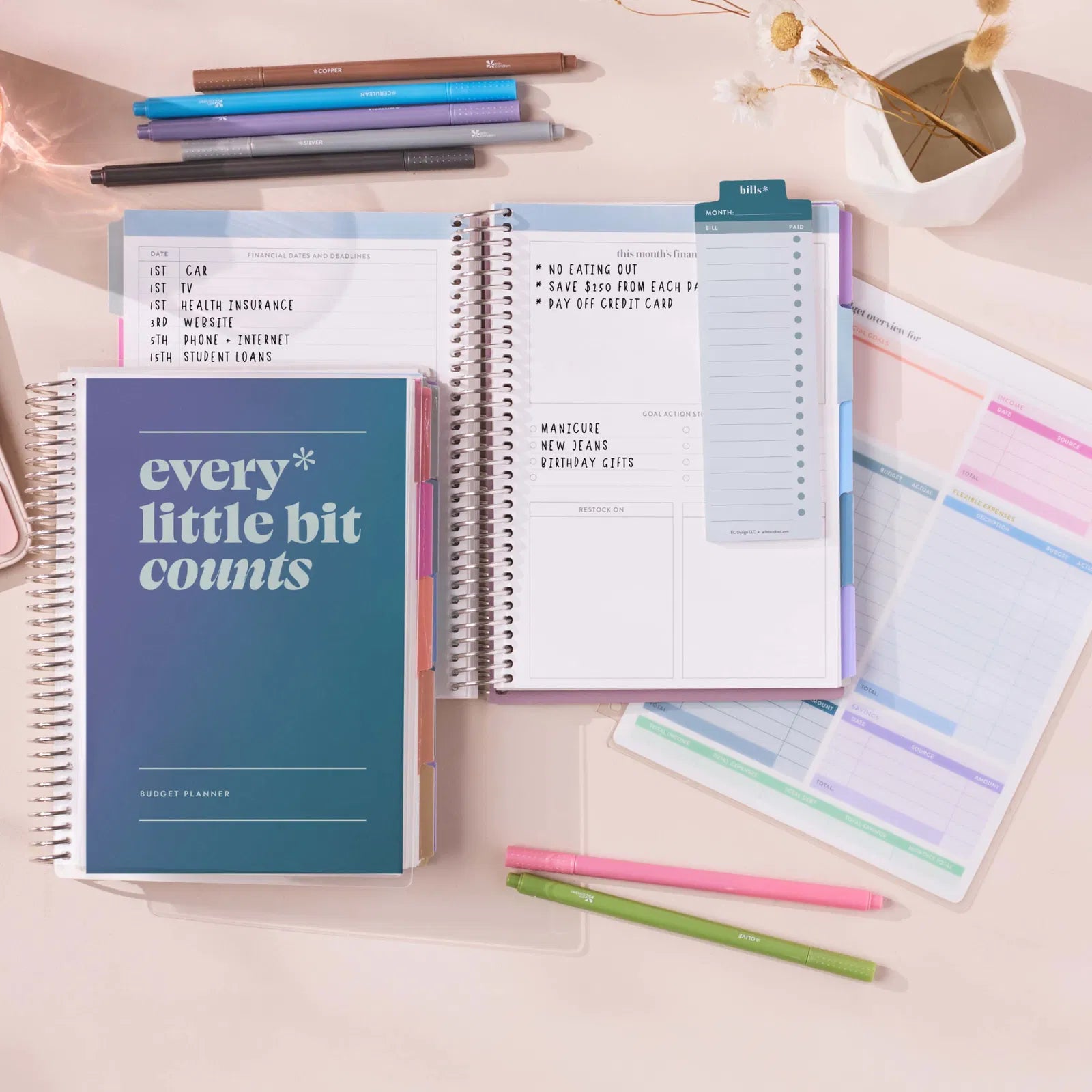 Open budget planner with colorful pens and sticky notes on a light surface