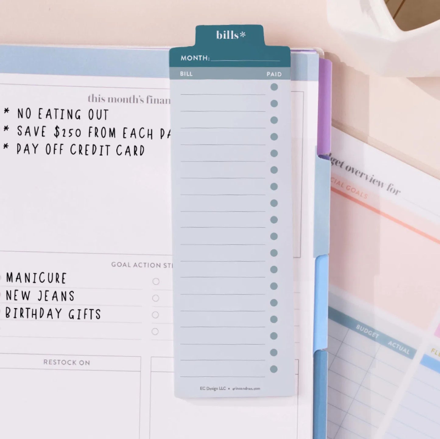 Planner with financial goals and tasks written on it, including no eating out, saving money, and paying off credit cards.